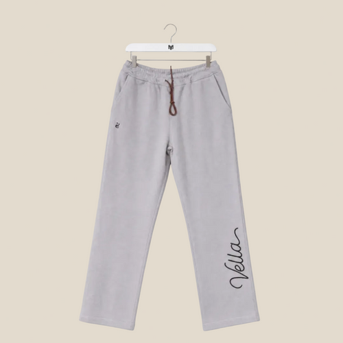 Gray sweatpants with 'Vella' branding on a beige background